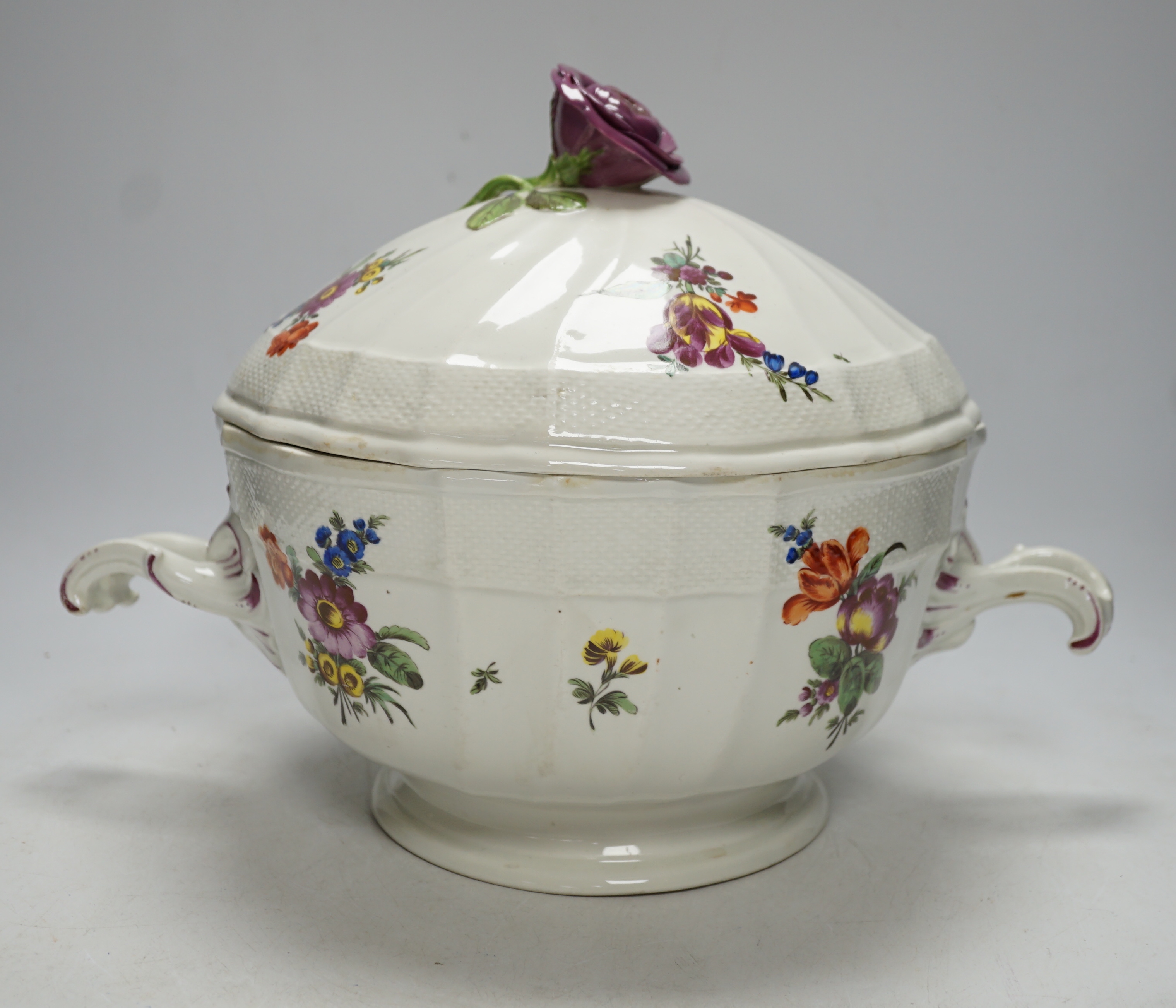 An 18th century Vienna tureen and cover, later outside decorated, with twin handles and floral knop, 38cm wide